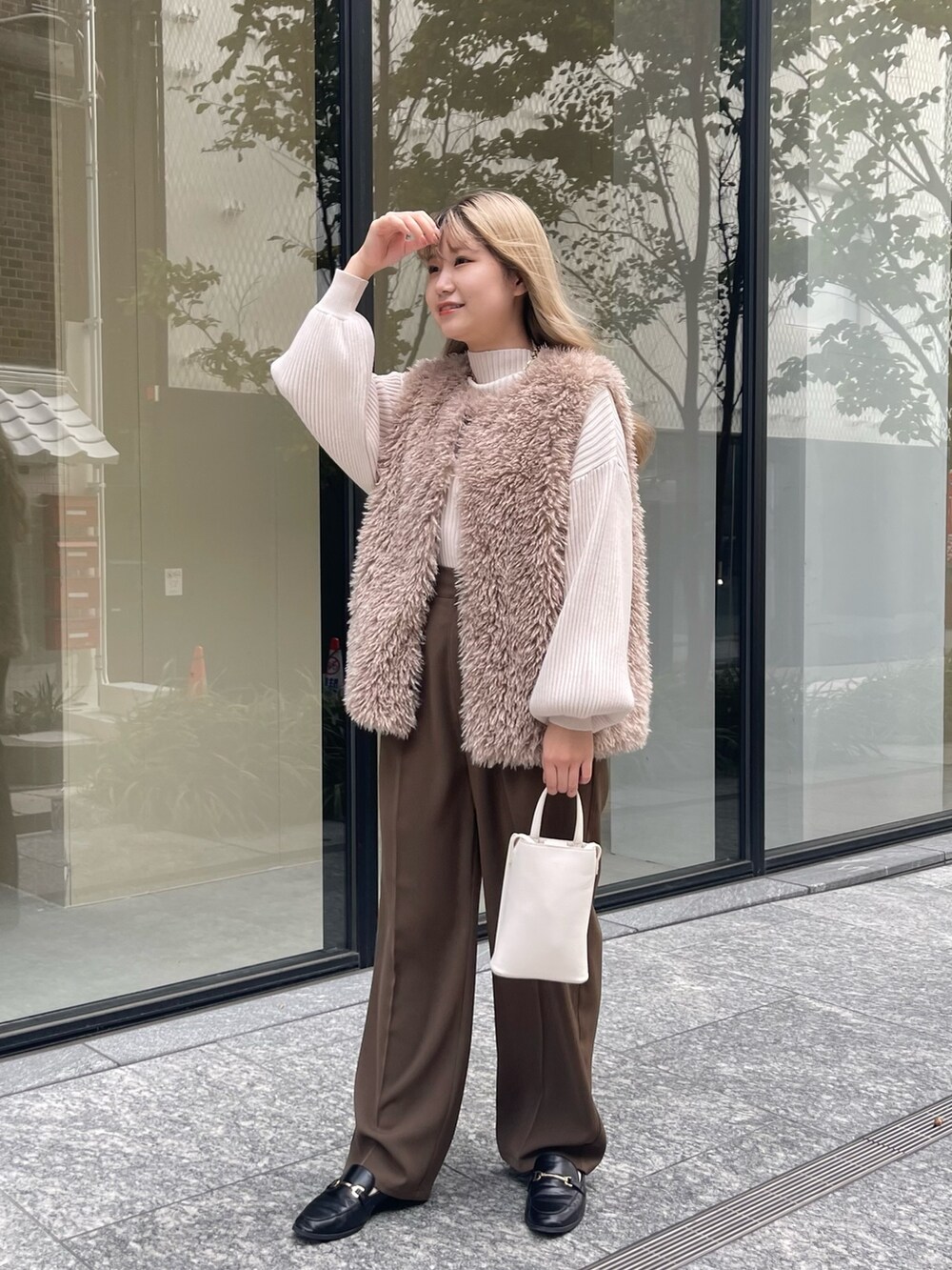 ホワイト系のニット/セーター、ベージュ系のベスト、ブラウン系のその他パンツを着用したレディースの秋コーディネートの5枚目の写真