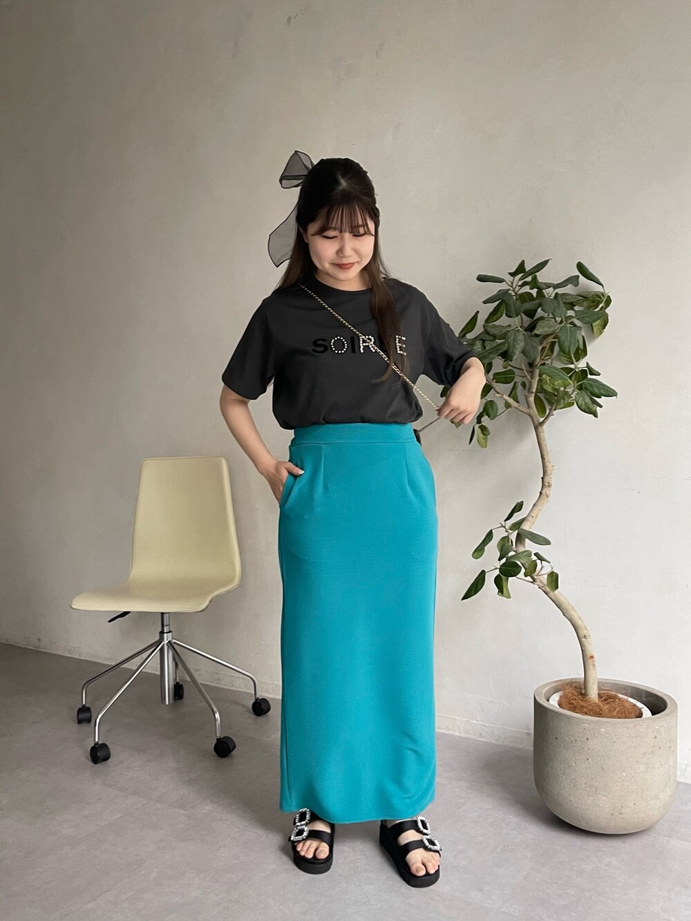 ブラック系のショルダーバッグ、ブラック系のサンダル、グレー系のTシャツ/カットソーを着用したレディースの春コーディネートの3枚目の写真