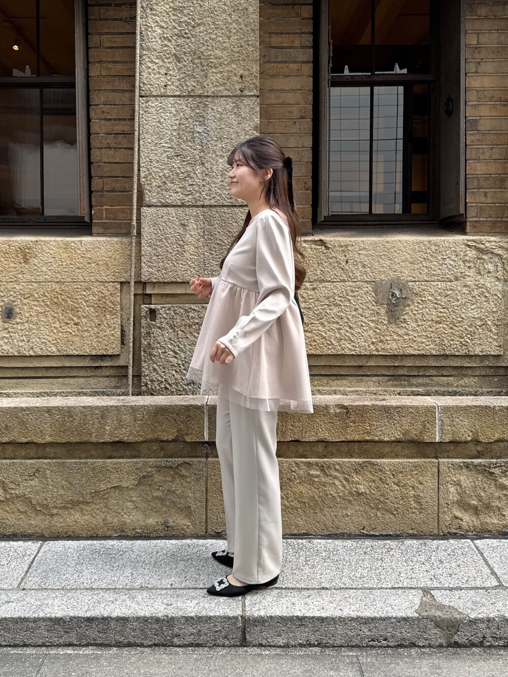 ベージュ系のシャツ/ブラウス、ブラック系のショルダーバッグ、ベージュ系のスラックスを着用したレディースの冬コーディネートの3枚目の写真