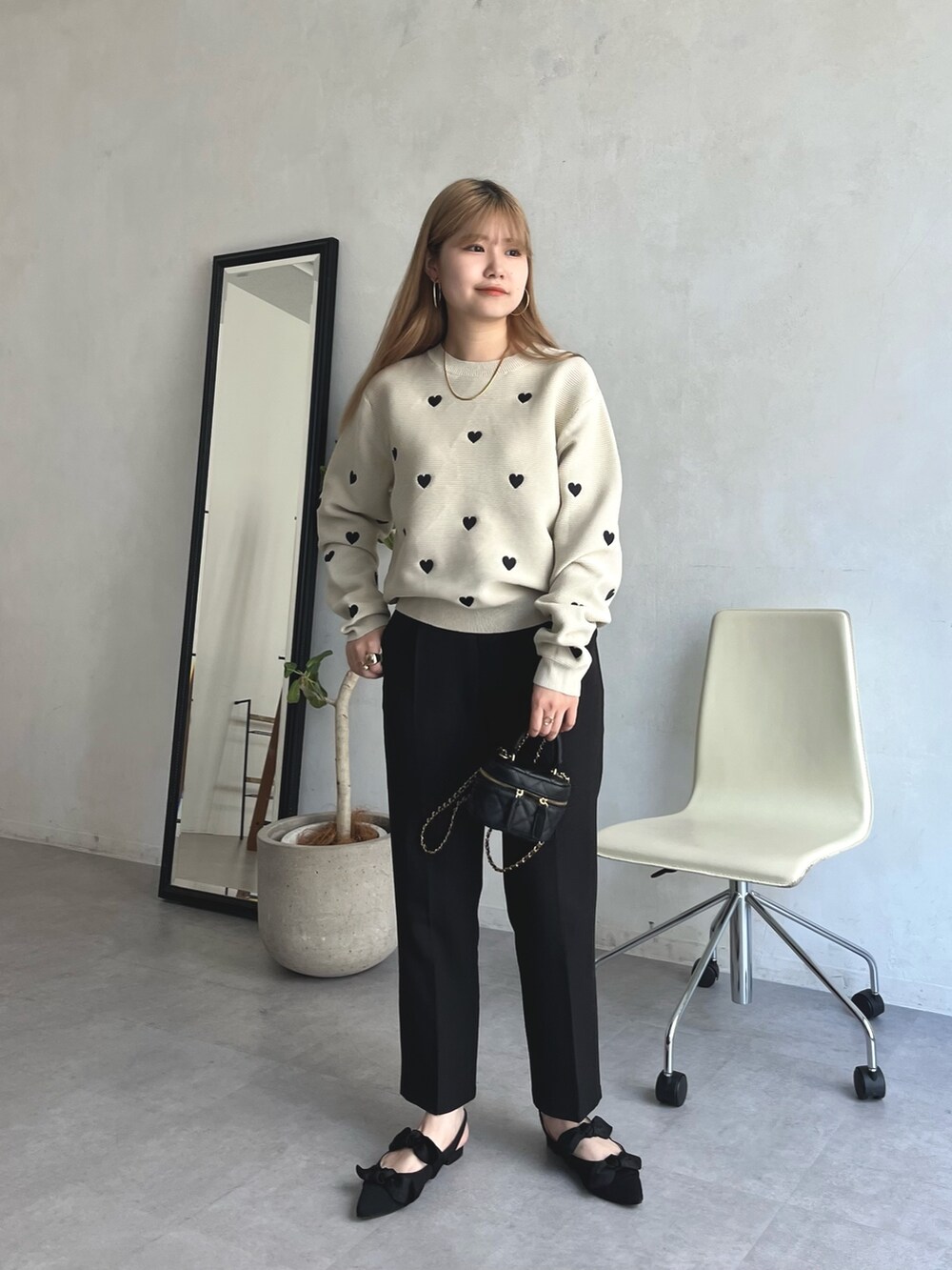 ベージュ系のニット/セーター、ブラック系のその他パンツ、ブラック系のパンプスを着用したレディースの夏コーディネートの2枚目の写真