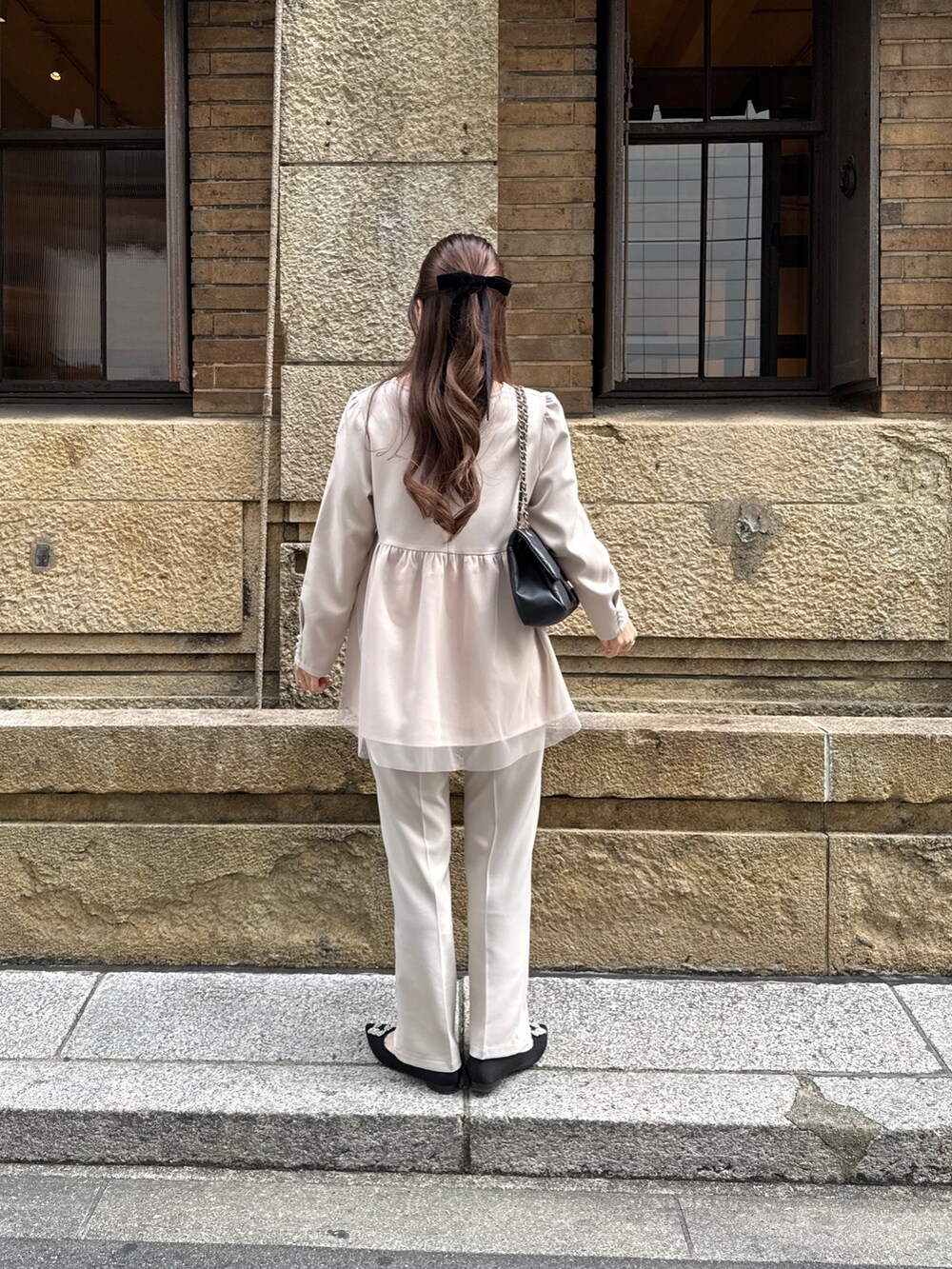 ベージュ系のシャツ/ブラウス、ブラック系のショルダーバッグ、ベージュ系のスラックスを着用したレディースの冬コーディネートの4枚目の写真