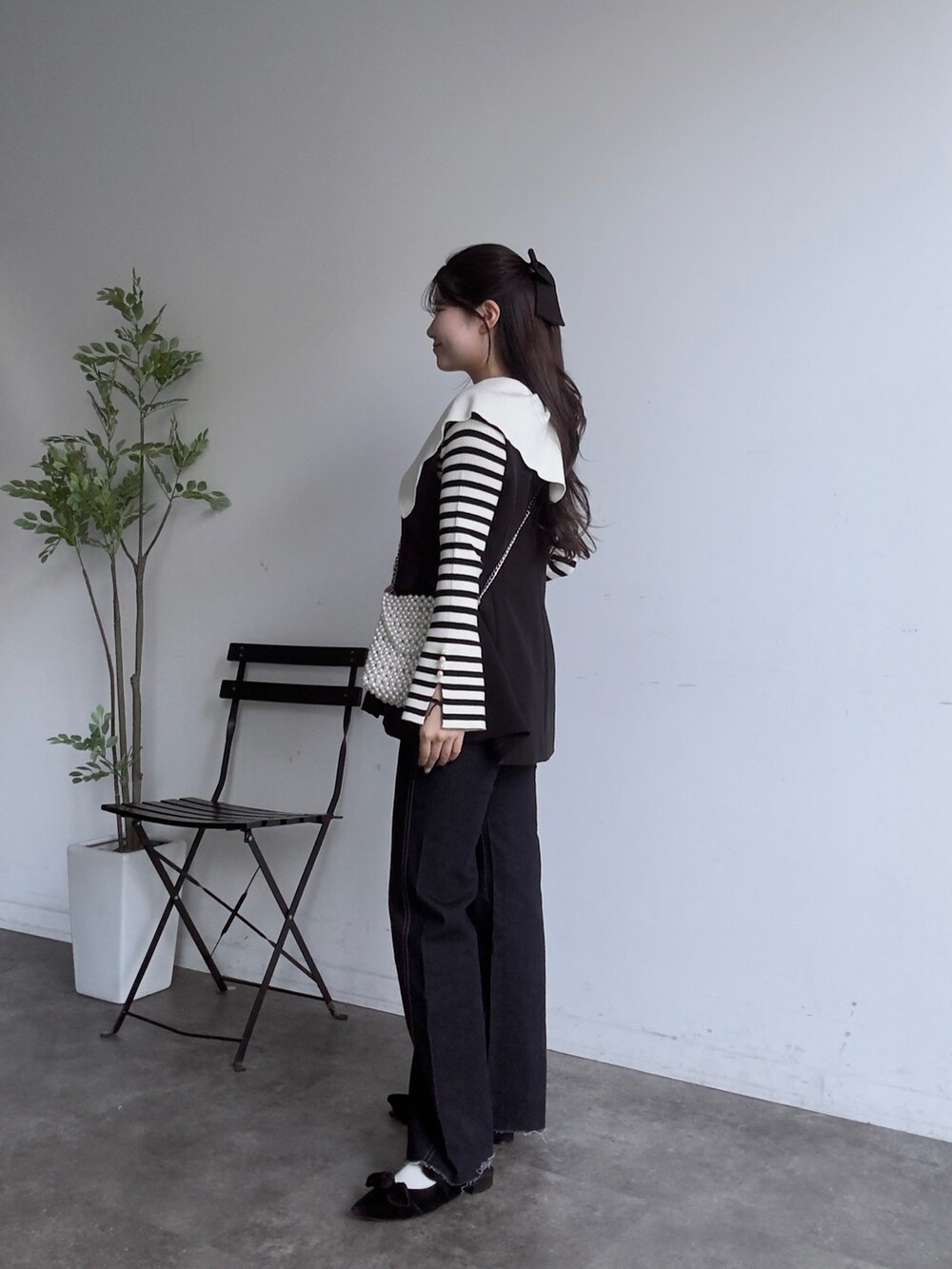 ホワイト系のニット/セーター、ブルー系のデニムパンツ、ブラック系のベストを着用したレディースの秋コーディネートの2枚目の写真