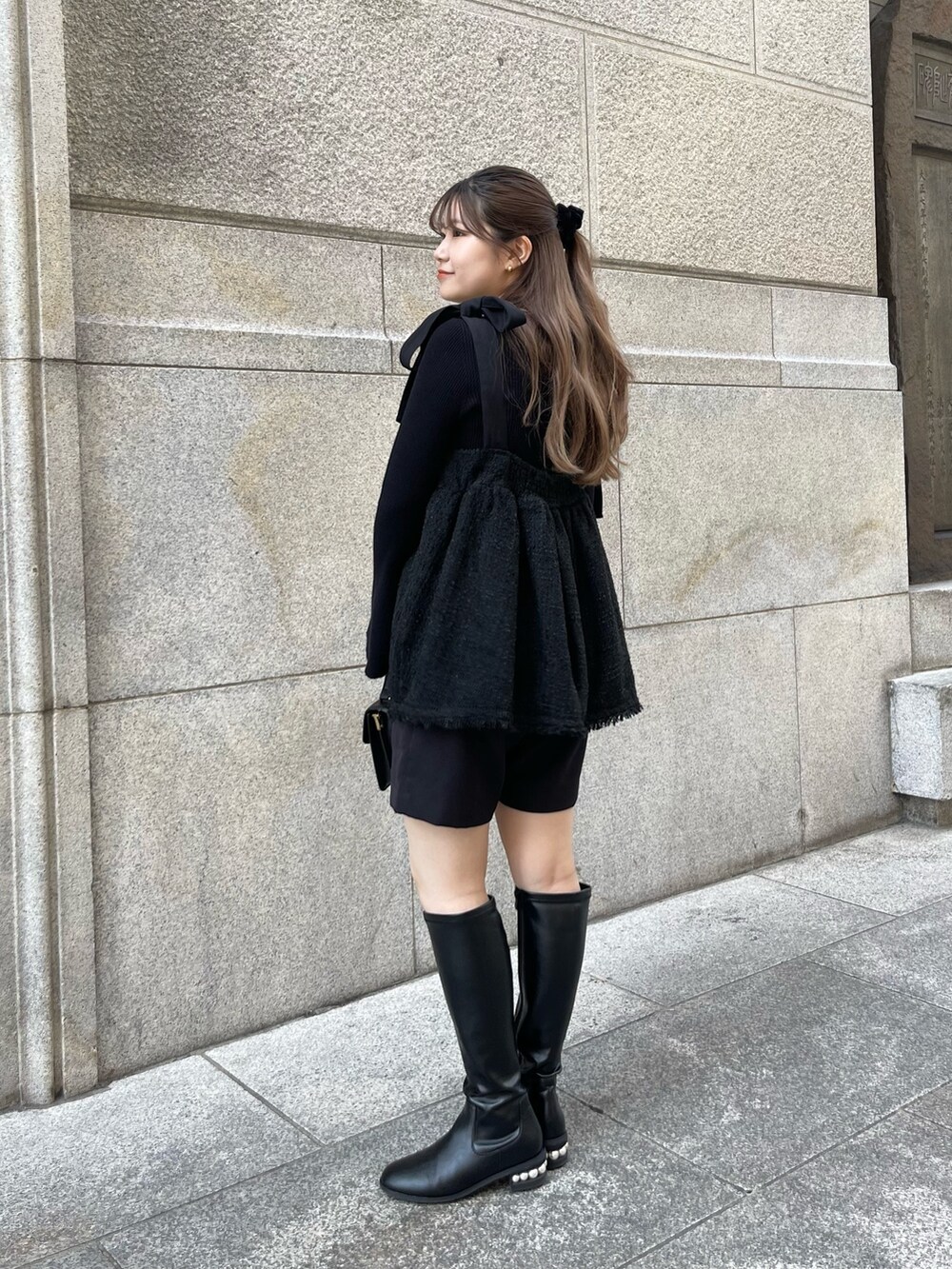 ブラック系のニット/セーター、ブラック系のブーツ、ブラック系のキャミソールを着用したレディースの秋コーディネートの2枚目の写真