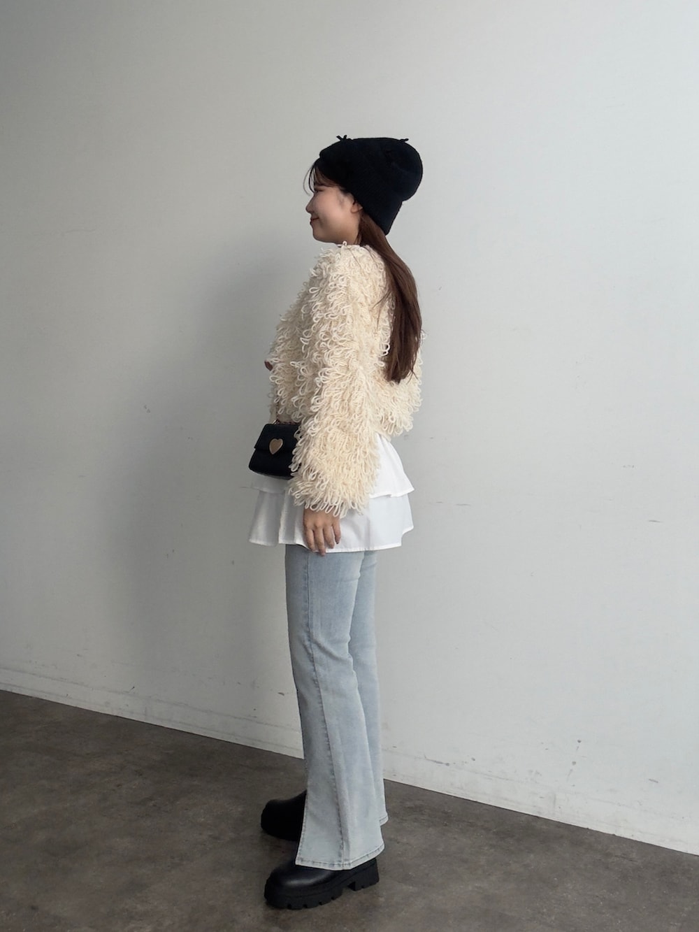 ブルー系のデニムパンツ、ブラック系のブーツ、ホワイト系のカーディガン/ボレロを着用したレディースの夏コーディネートの2枚目の写真