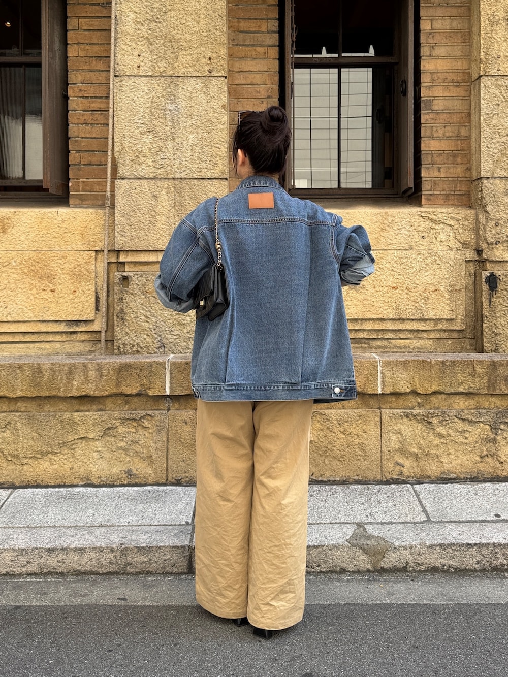 ブラック系のTシャツ/カットソー、ベージュ系のチノパンツ、ブラック系のサンダルを着用したレディースの春コーディネートの3枚目の写真