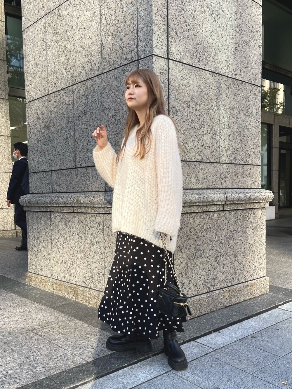 ベージュ系のニット/セーター、ブラック系のブーツ、ブラック系のショルダーバッグを着用したレディースの秋コーディネートの4枚目の写真