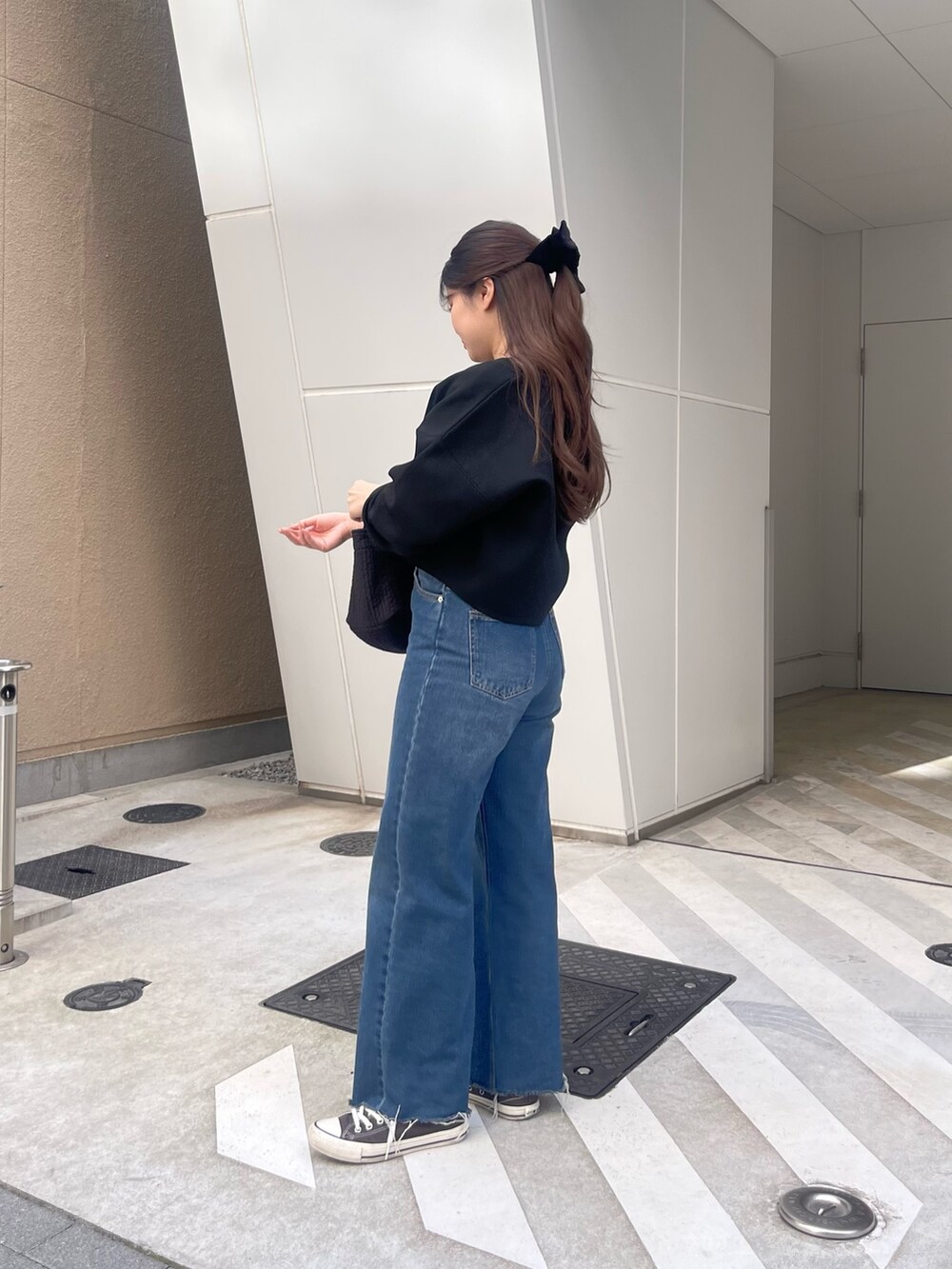 ブラック系のTシャツ/カットソー、ブラック系のカーディガン/ボレロ、ブラック系のトートバッグを着用したレディースの春コーディネートの2枚目の写真