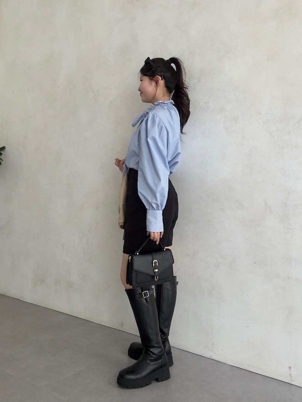 ブラック系のその他パンツ、ブラック系のブーツ、ブルー系のシャツ/ブラウスを着用したレディースの冬コーディネートの2枚目の写真