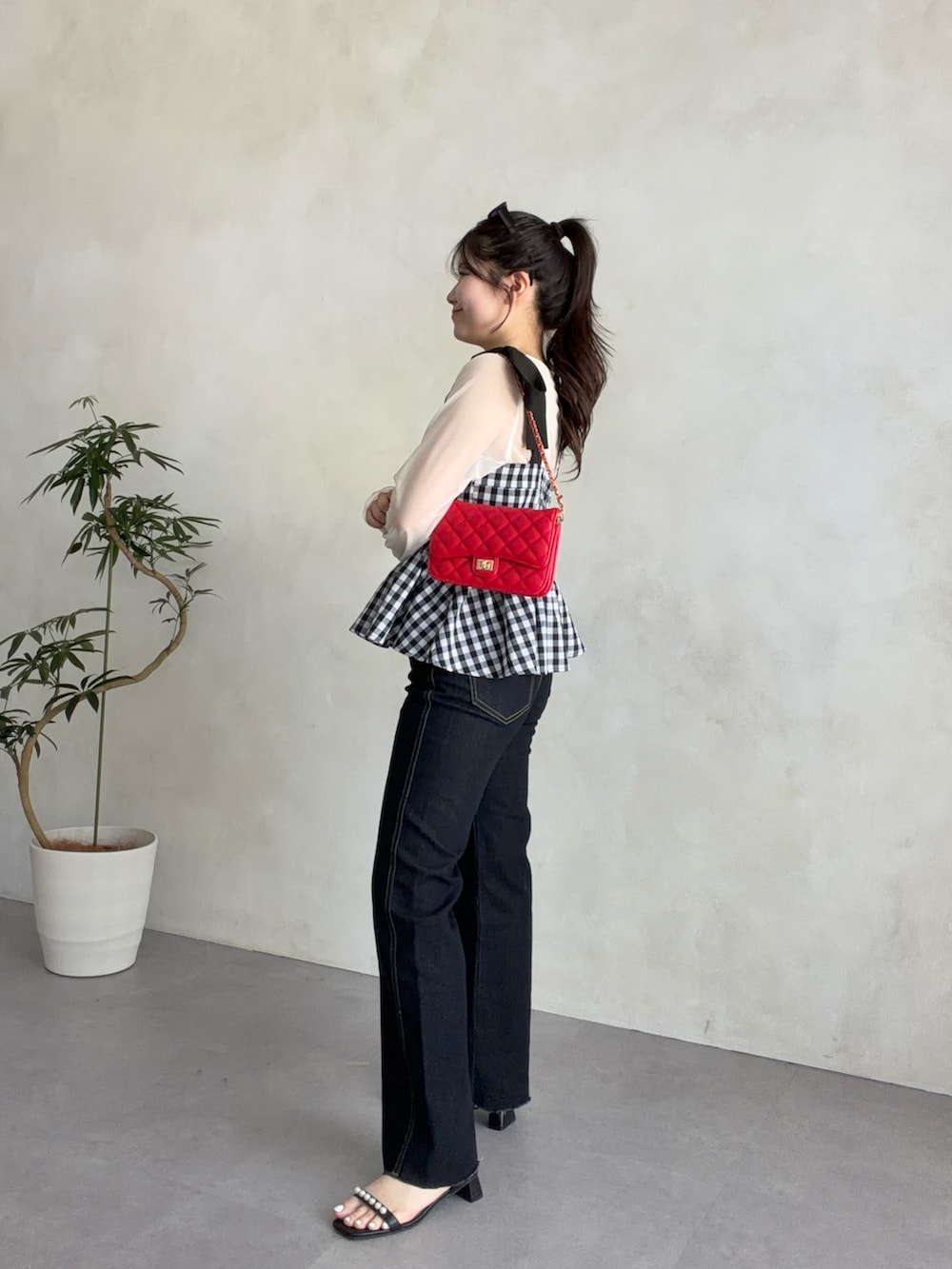 レッド系のトートバッグ、ホワイト系のTシャツ/カットソー、ブルー系のデニムパンツを着用したレディースの春コーディネートの2枚目の写真