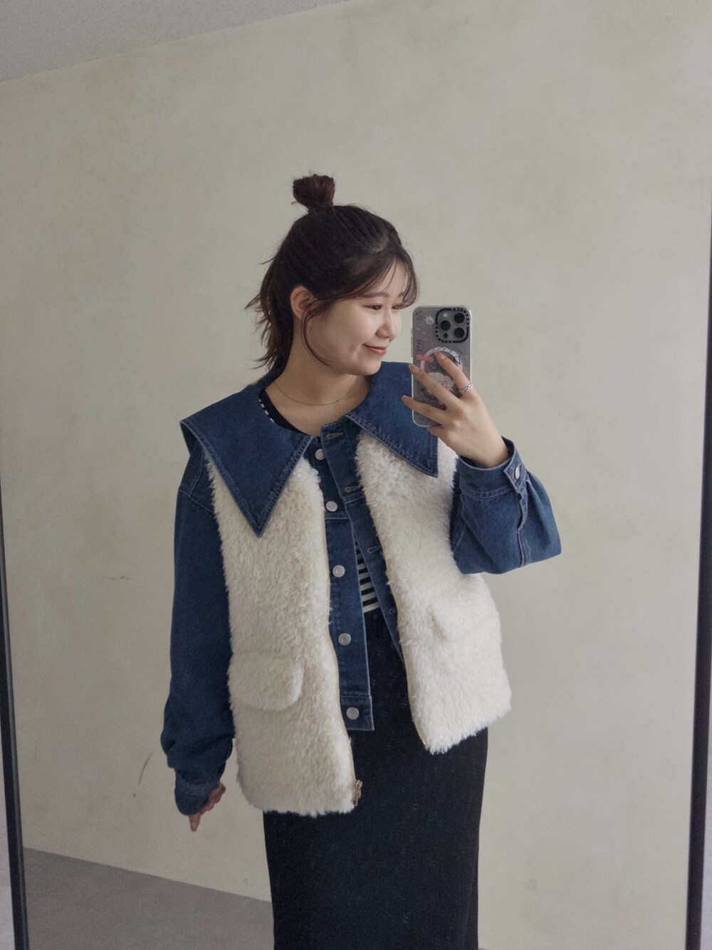 ブルー系のデニムジャケット、ブラック系のスカート、ブラック系のブーツを着用したレディースの夏コーディネートの2枚目の写真