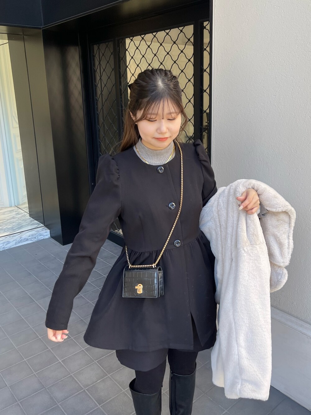 グレー系のニット/セーター、ブラック系のその他パンツ、ブラック系のブーツを着用したレディースの冬コーディネートの3枚目の写真