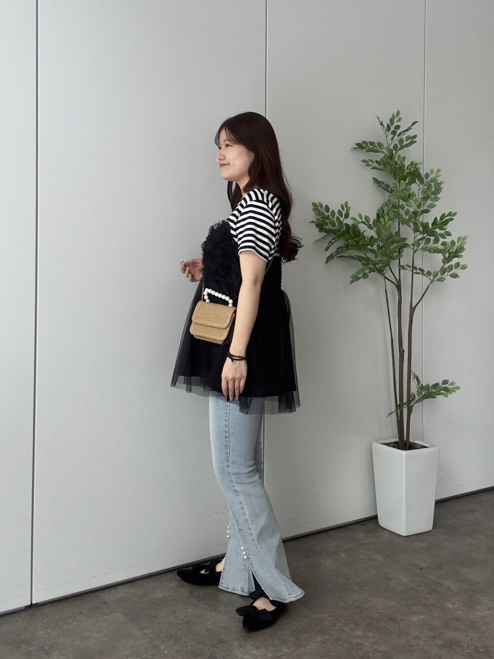 ブラック系のTシャツ/カットソー、ブルー系のデニムパンツ、ブラック系のパンプスを着用したレディースの夏コーディネートの2枚目の写真