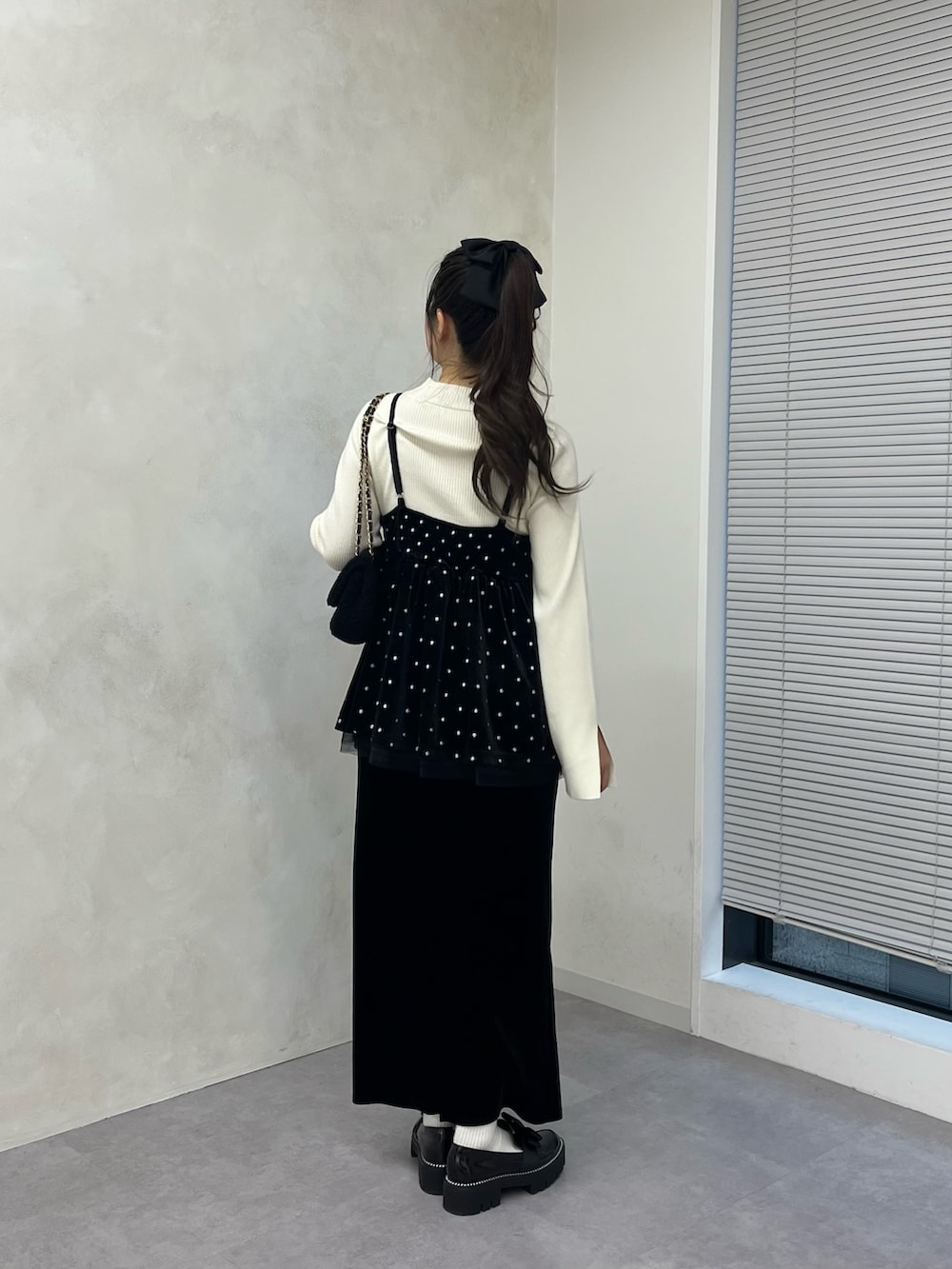 ホワイト系のニット/セーター、ブラック系のスカート、ブラック系のローファーを着用したレディースの秋コーディネートの3枚目の写真