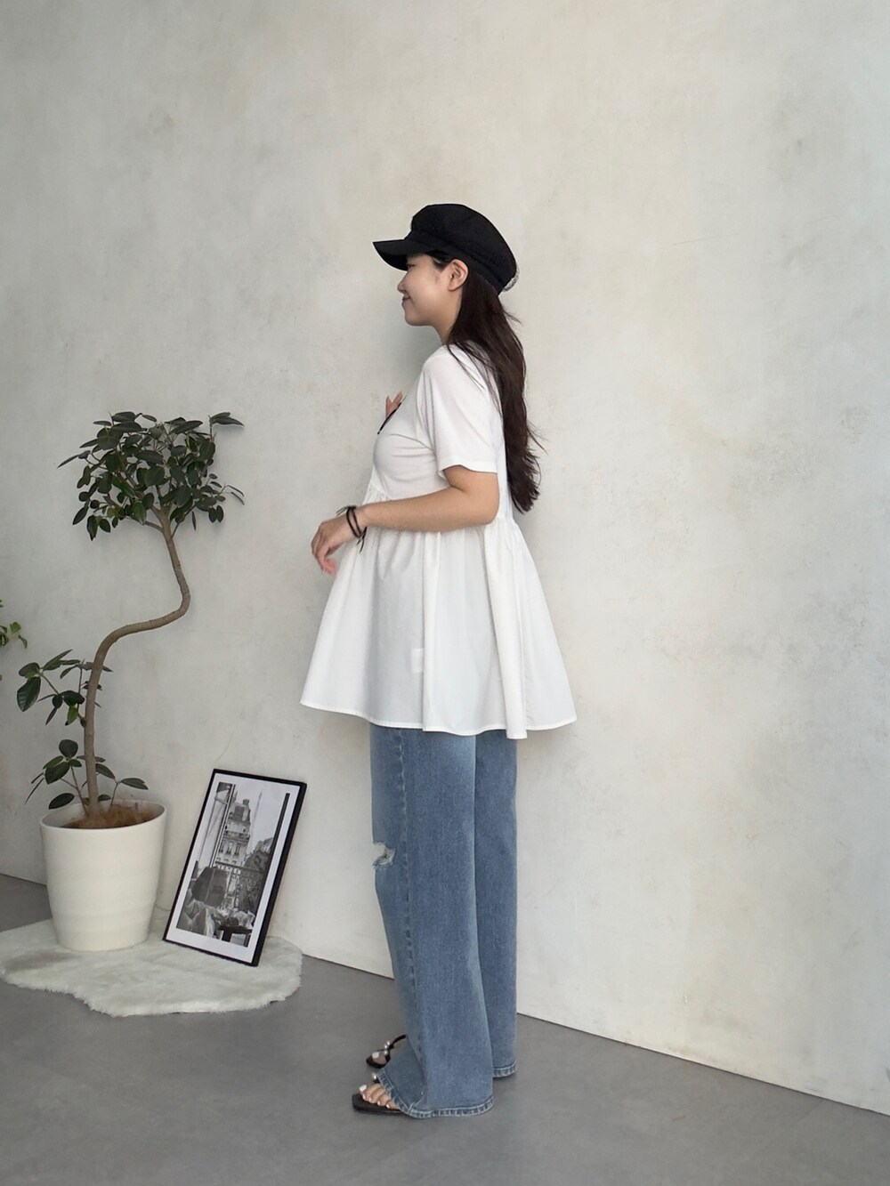 ベージュ系のかごバッグ、ブルー系のデニムパンツ、ブラック系のサンダルを着用したレディースの夏コーディネートの2枚目の写真