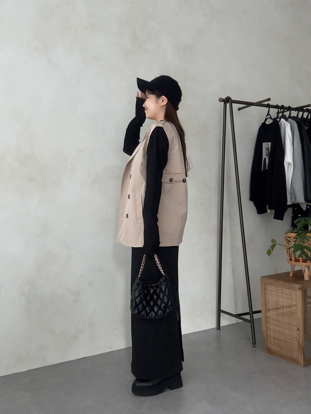 ブラック系のスカート、ブラック系のブーツ、ブラック系のショルダーバッグを着用したレディースの夏コーディネートの2枚目の写真