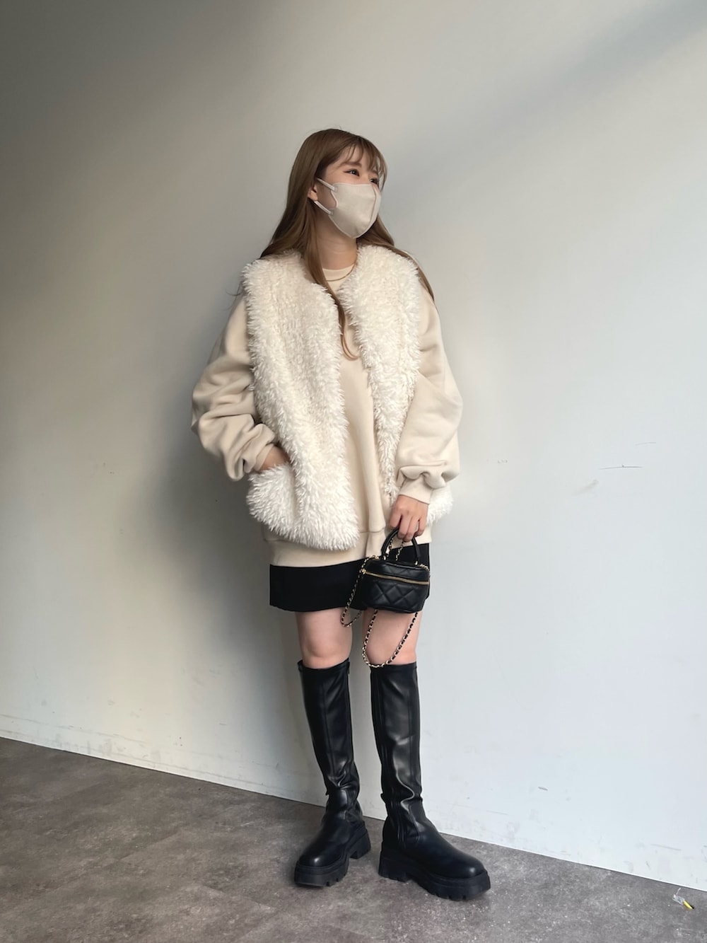 ホワイト系のスウェット、ホワイト系のベスト、ブラック系のその他パンツを着用したレディースの秋コーディネートの5枚目の写真