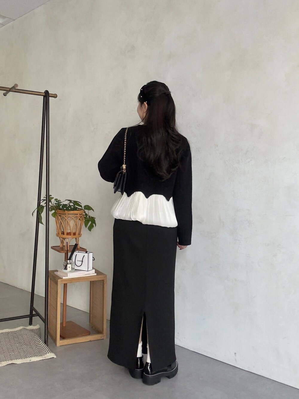 ブラック系のカーディガン/ボレロ、ブラック系のスカート、ブラック系のローファーを着用したレディースの冬コーディネートの3枚目の写真