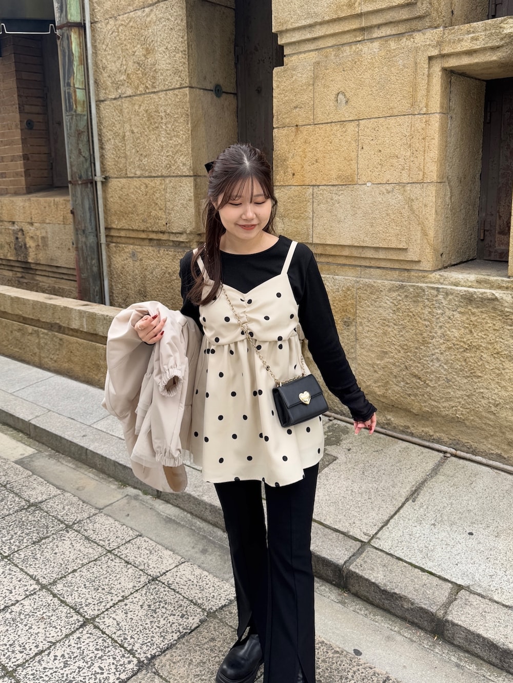 ブラック系のTシャツ/カットソー、ブラック系のショルダーバッグ、ホワイト系のキャミソールを着用したレディースの冬コーディネートの3枚目の写真