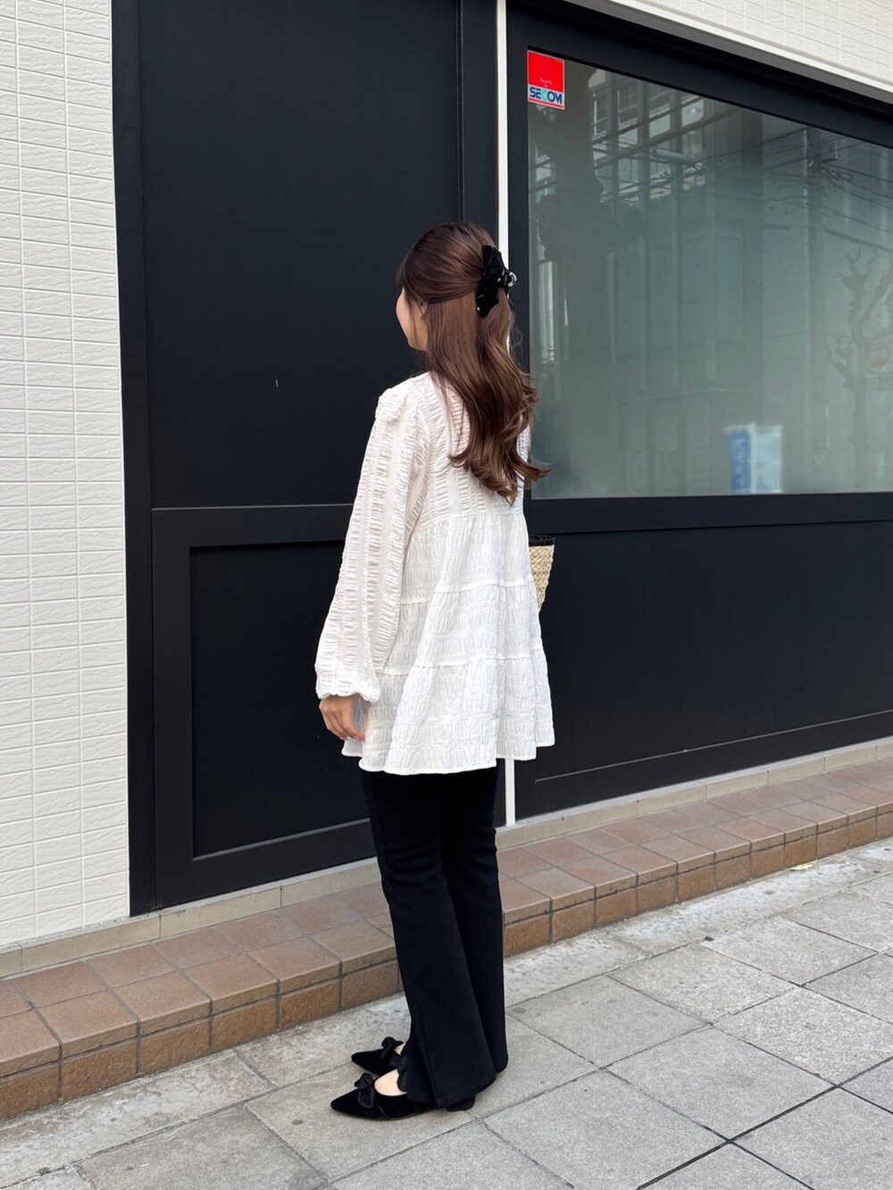 ブラック系のその他パンツ、ブラック系のパンプス、ホワイト系のシャツ/ブラウスを着用したレディースの春コーディネートの2枚目の写真