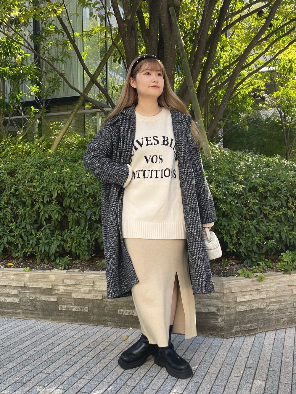 ホワイト系のニット/セーター、ベージュ系のセットアップ、ブラック系のブーツを着用したレディースの秋コーディネートの3枚目の写真