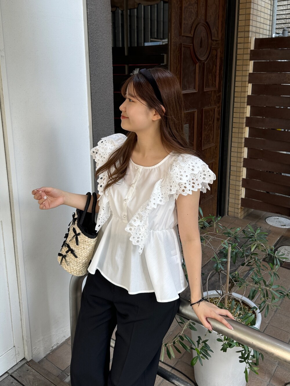 ホワイト系のシャツ/ブラウス、ブラック系のスラックス、ブラック系のかごバッグを着用したレディースの夏コーディネートの2枚目の写真