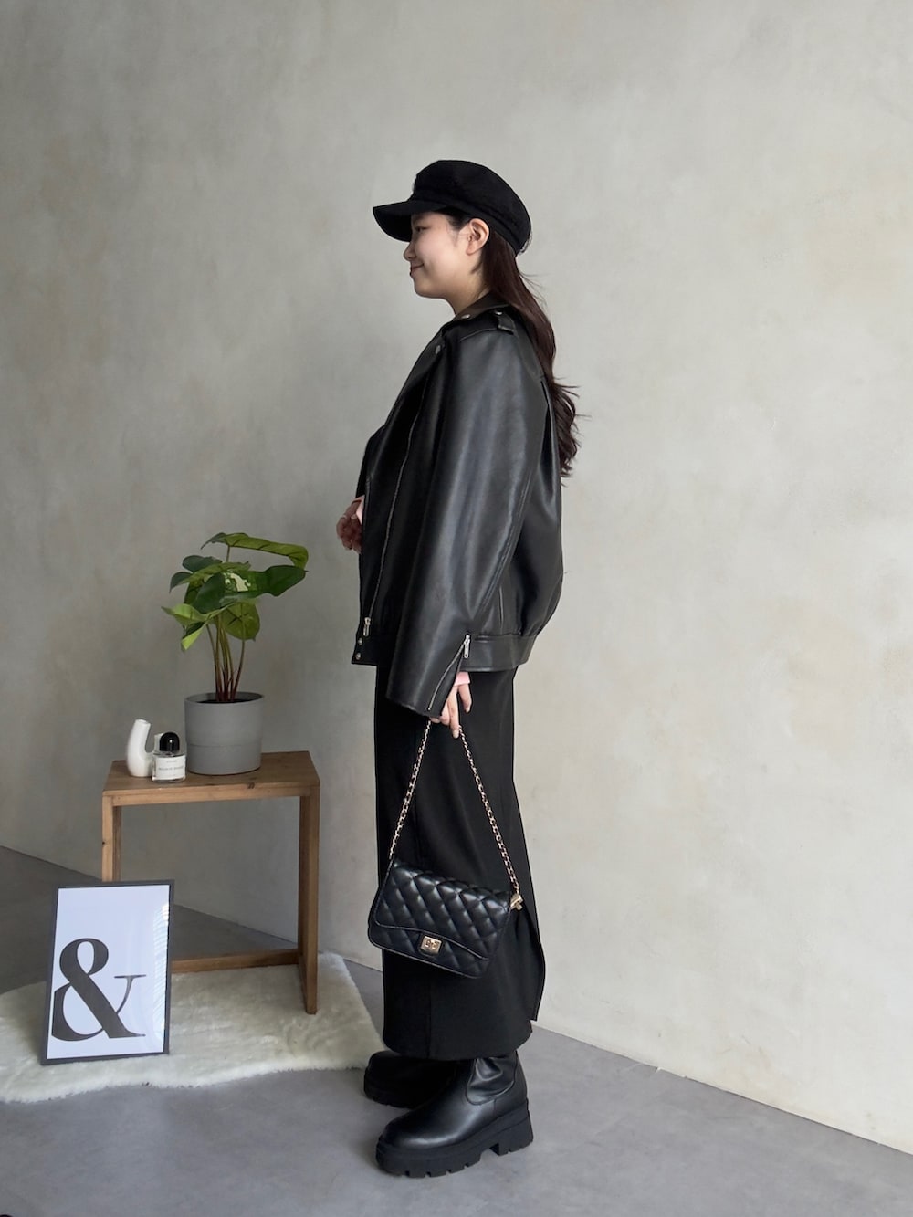 ブラック系のライダースジャケット、ブラック系のスカート、ブラック系のブーツを着用したレディースの冬コーディネートの2枚目の写真