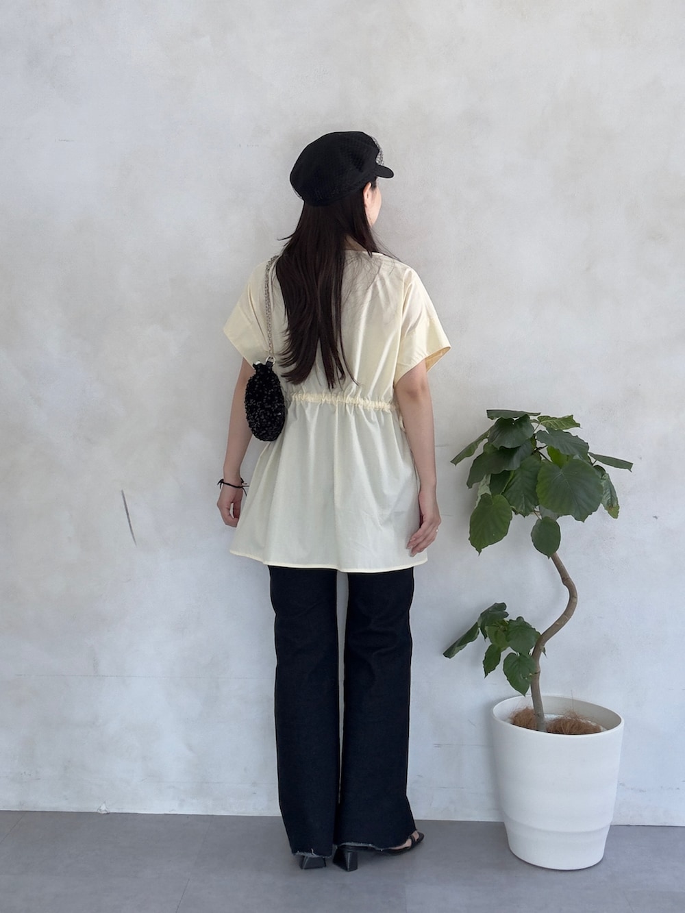 ブルー系のデニムパンツ、ブラック系のサンダル、イエロー系のシャツ/ブラウスを着用したレディースの夏コーディネートの3枚目の写真