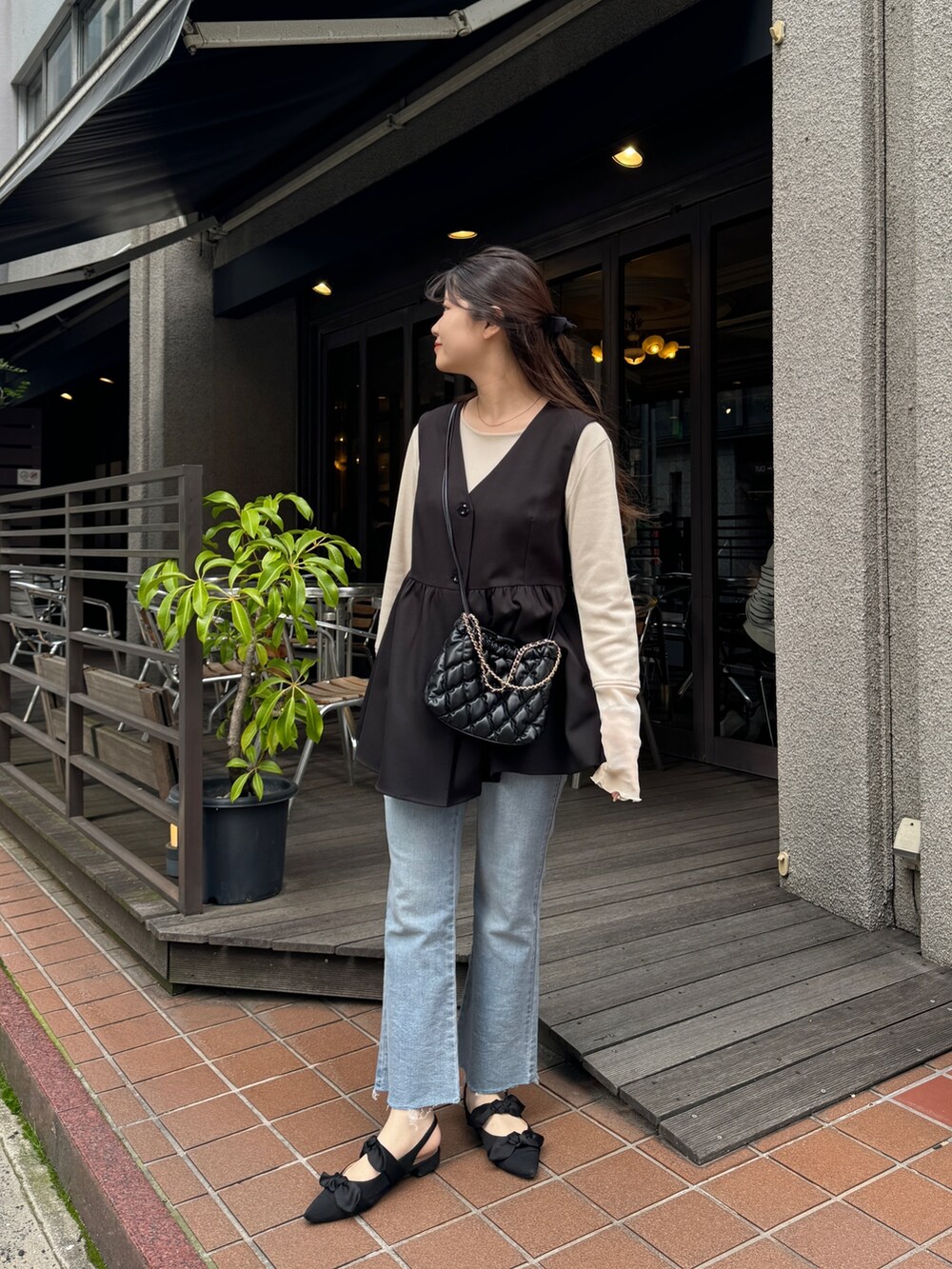 ホワイト系のTシャツ/カットソー、ブラック系のショルダーバッグ、ブルー系のデニムパンツを着用したレディースの春コーディネートの3枚目の写真