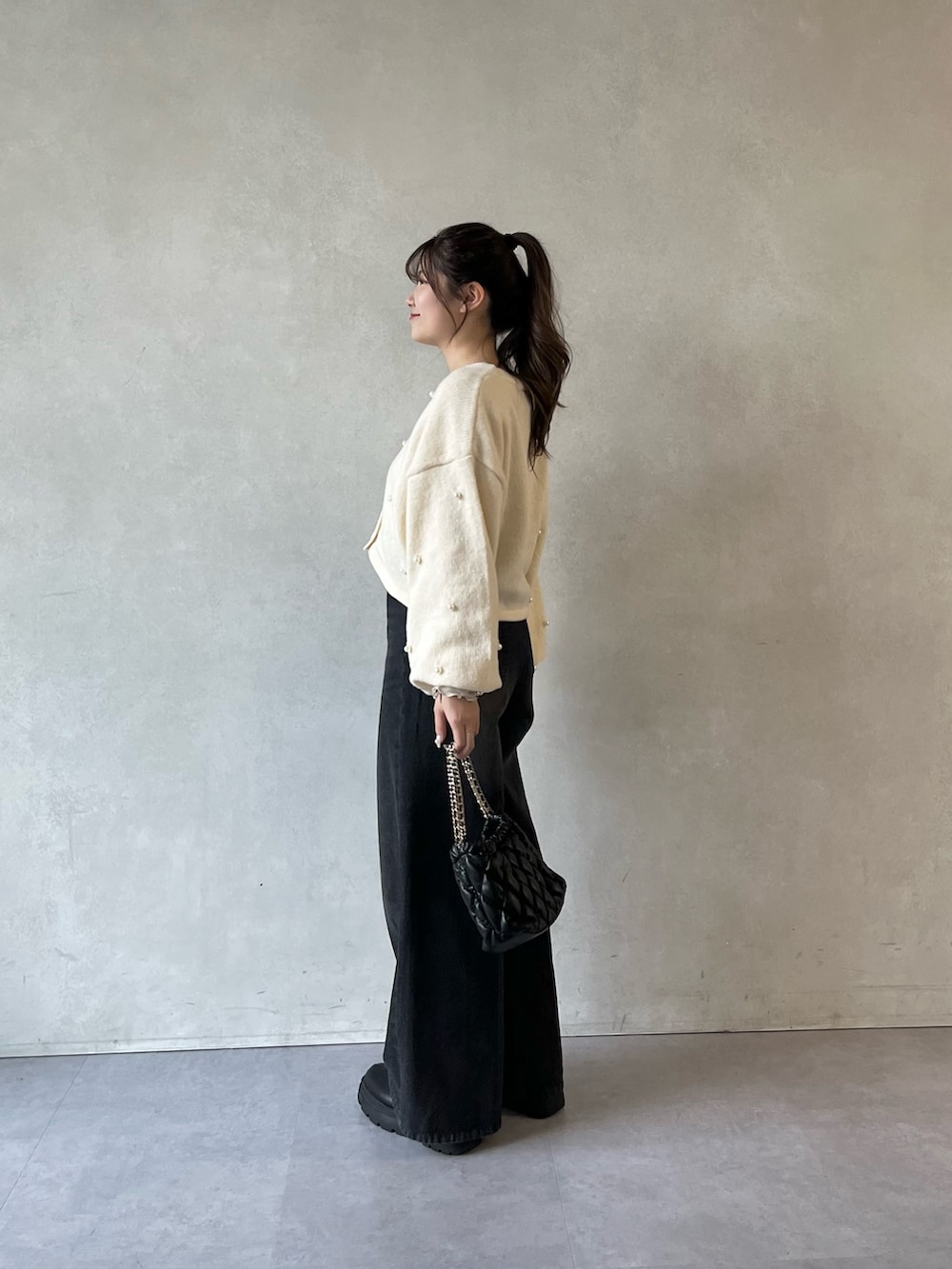 ホワイト系のTシャツ/カットソー、ホワイト系のカーディガン/ボレロ、ブラック系のショルダーバッグを着用したレディースの冬コーディネートの2枚目の写真