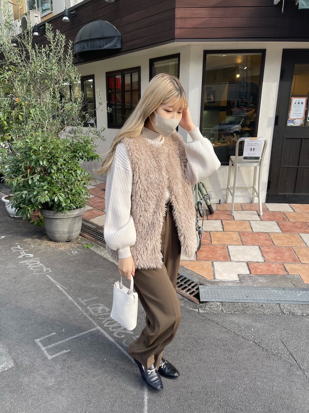 ホワイト系のニット/セーター、ベージュ系のベスト、ブラウン系のその他パンツを着用したレディースの秋コーディネートの3枚目の写真