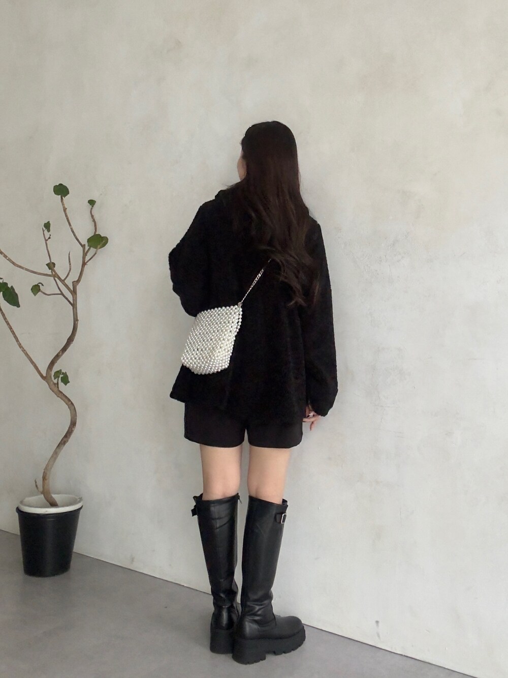 ブラック系のニット/セーター、ブラック系のその他パンツ、ブラック系のブーツを着用したレディースの秋コーディネートの3枚目の写真