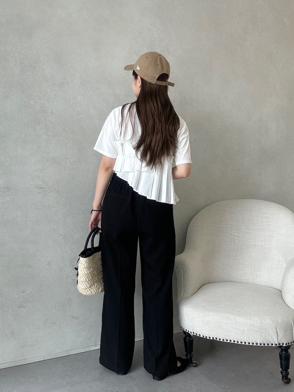 ブラック系のかごバッグ、ブラック系のスラックス、ブラック系のパンプスを着用したレディースの夏コーディネートの3枚目の写真