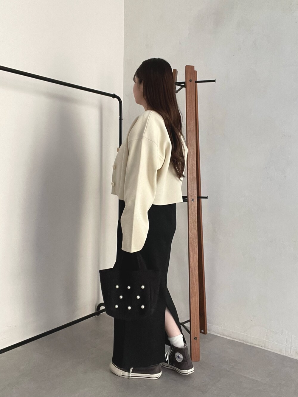 ホワイト系のカーディガン/ボレロ、ブラック系のトートバッグ、ブラック系のスカートを着用したレディースの春コーディネートの2枚目の写真