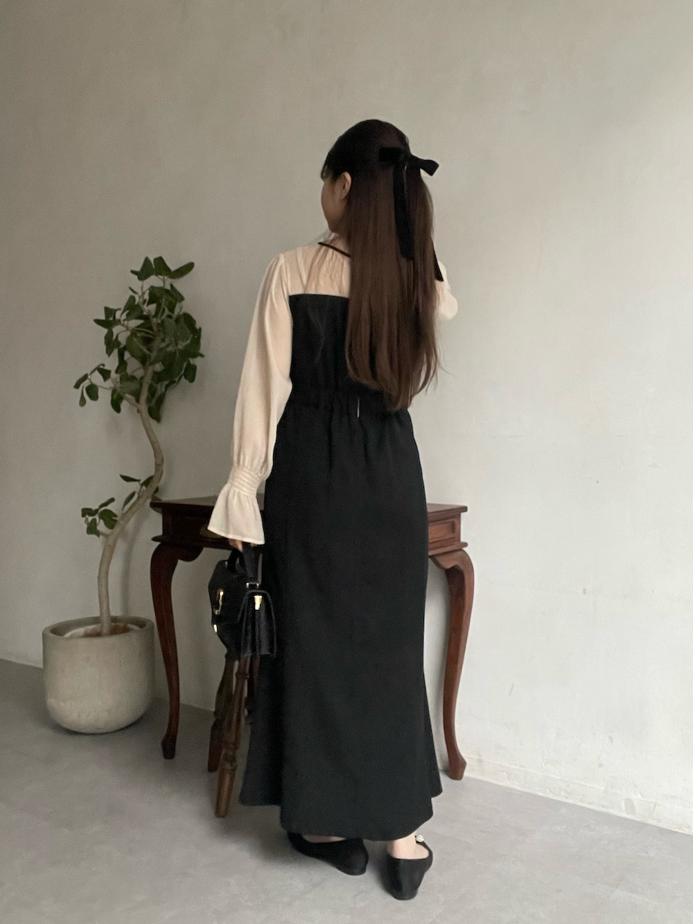 ブラック系のドレス、ブラック系のパンプス、ブラック系のその他ヘアアクセサリーを着用したレディースの春コーディネートの3枚目の写真