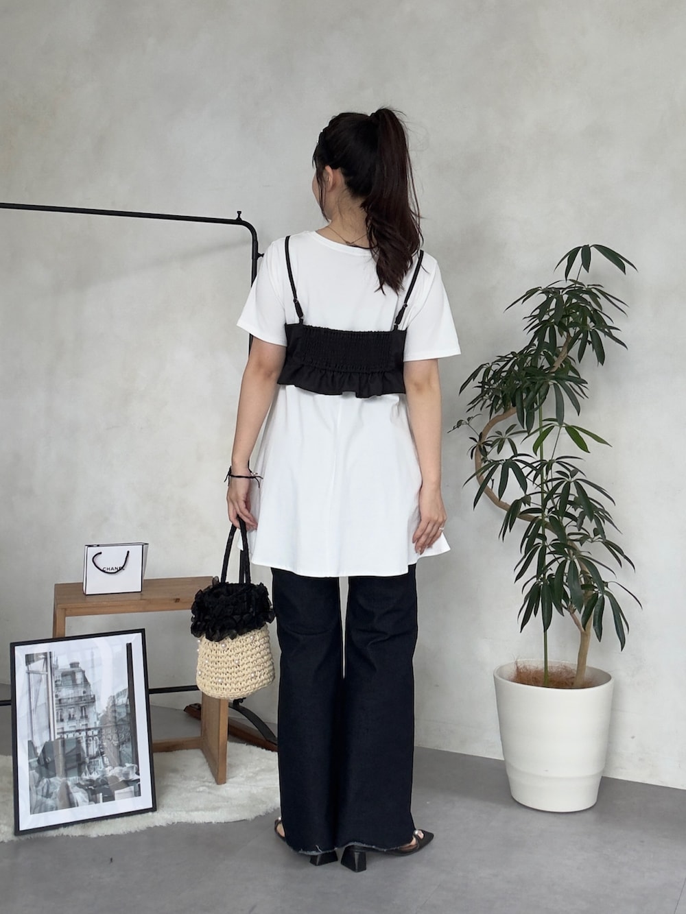 ベージュ系のかごバッグ、ブルー系のデニムパンツ、ブラック系のサンダルを着用したレディースの夏コーディネートの3枚目の写真