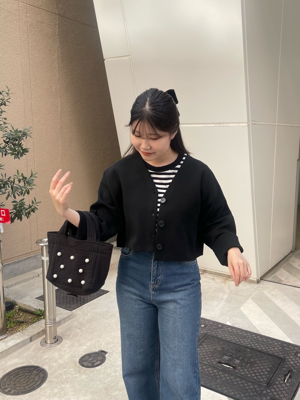 ブラック系のTシャツ/カットソー、ブラック系のカーディガン/ボレロ、ブラック系のトートバッグを着用したレディースの春コーディネートの3枚目の写真