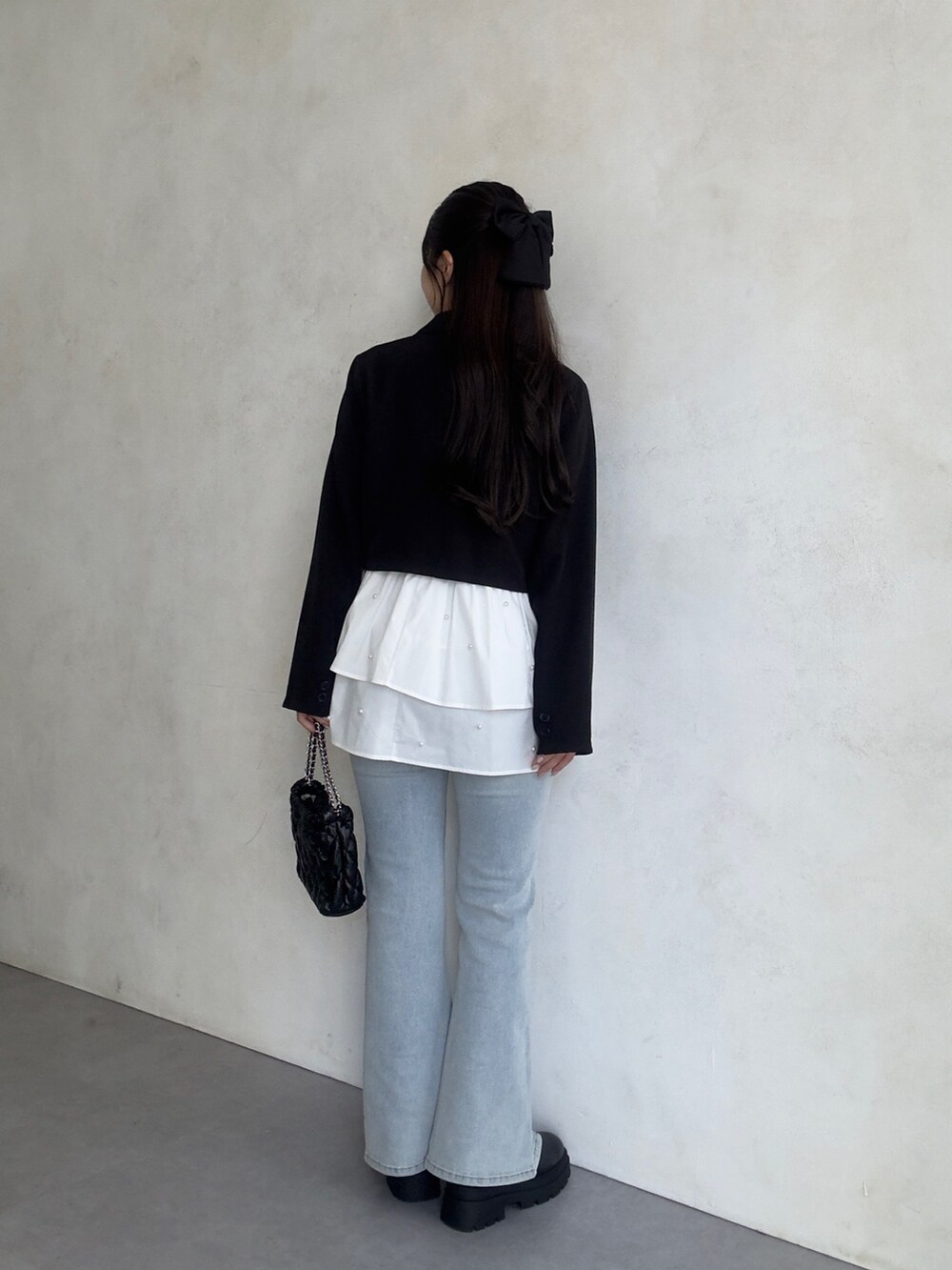 ブルー系のデニムパンツ、ブラック系のブーツ、ホワイト系のTシャツ/カットソーを着用したレディースの秋コーディネートの3枚目の写真