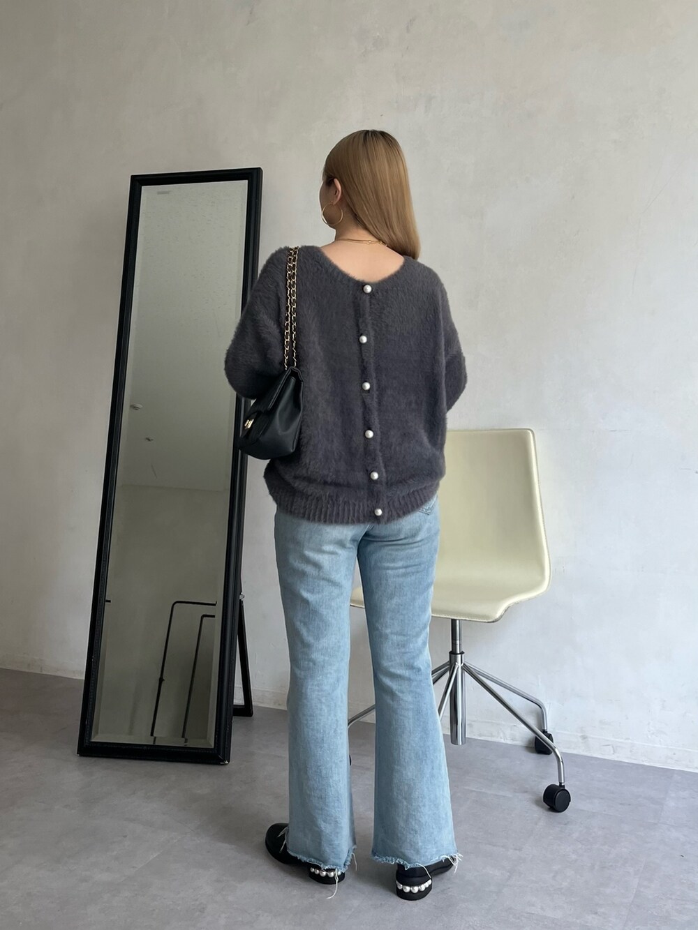 ブルー系のデニムパンツ、グレー系のカーディガン/ボレロ、ゴールド系のネックレスを着用したレディースの夏コーディネートの2枚目の写真