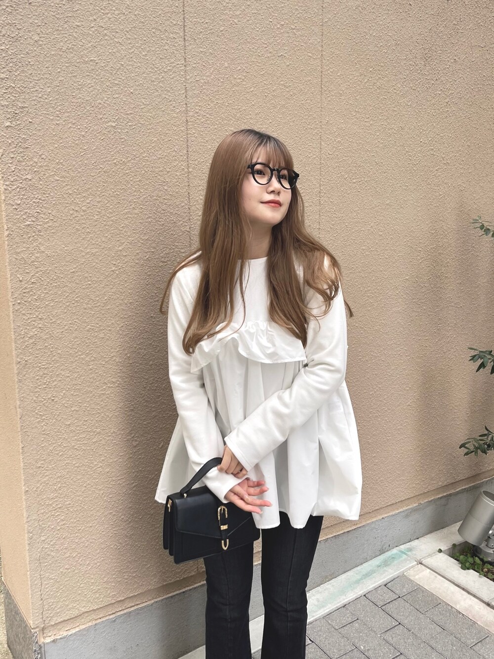 ブラック系のデニムパンツ、ホワイト系のTシャツ/カットソーを着用したレディースの冬コーディネートの4枚目の写真