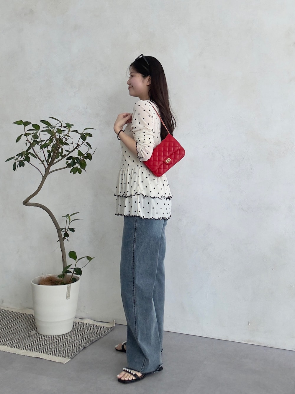 ホワイト系のTシャツ/カットソー、ブルー系のデニムパンツ、レッド系のトートバッグを着用したレディースの春コーディネートの2枚目の写真