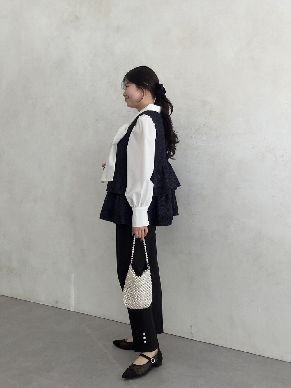 ホワイト系のシャツ/ブラウス、ブラック系のベスト、ブラック系のその他パンツを着用したレディースの冬コーディネートの2枚目の写真