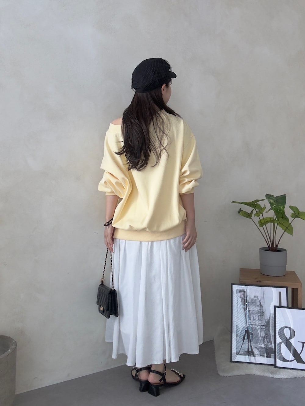 ホワイト系のスカート、ブラック系のサンダル、ブラック系のトートバッグを着用したレディースの春コーディネートの3枚目の写真