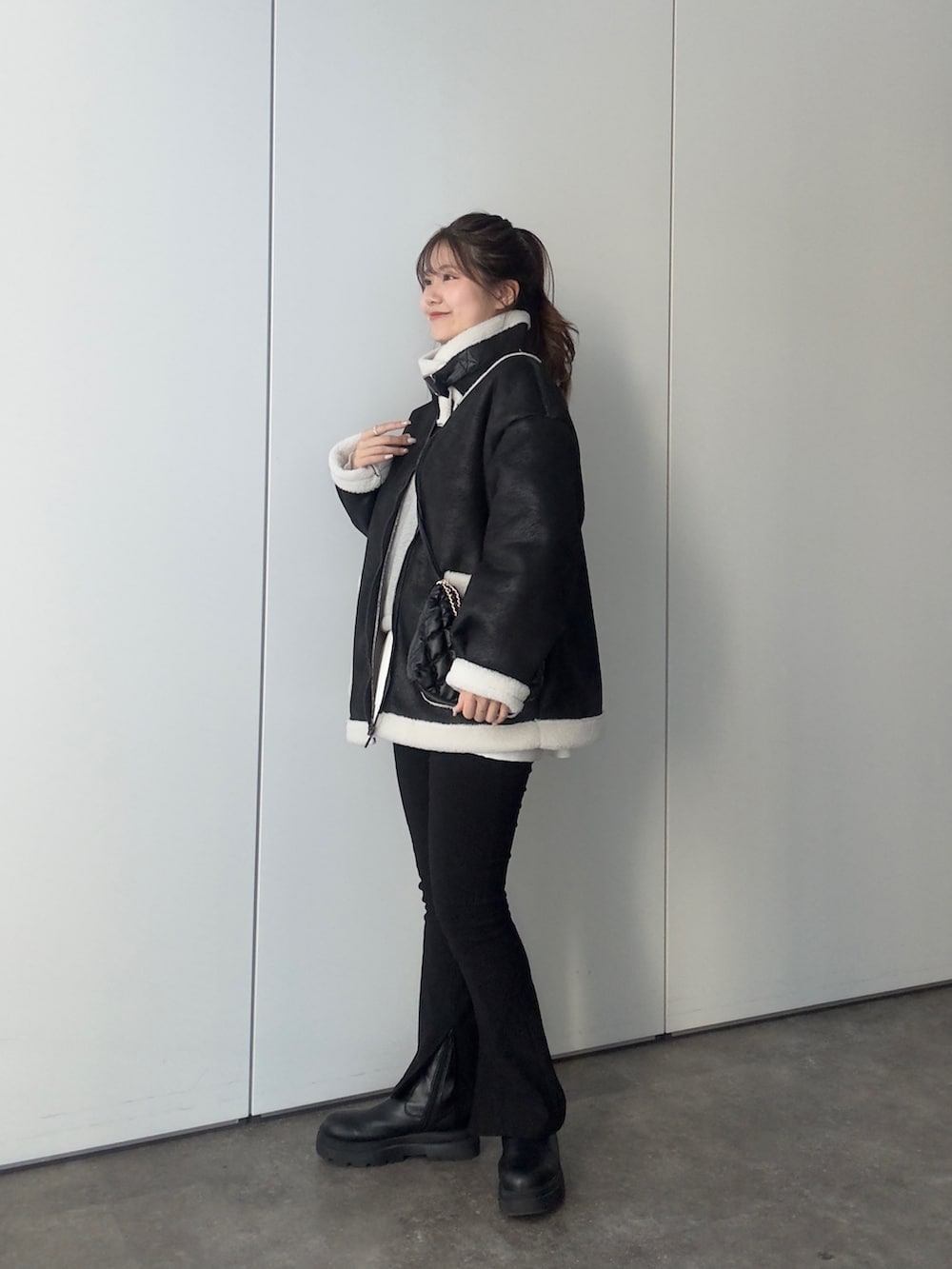 グレー系のTシャツ/カットソー、ブラック系のショルダーバッグ、ホワイト系のTシャツ/カットソーを着用したレディースの冬コーディネートの2枚目の写真