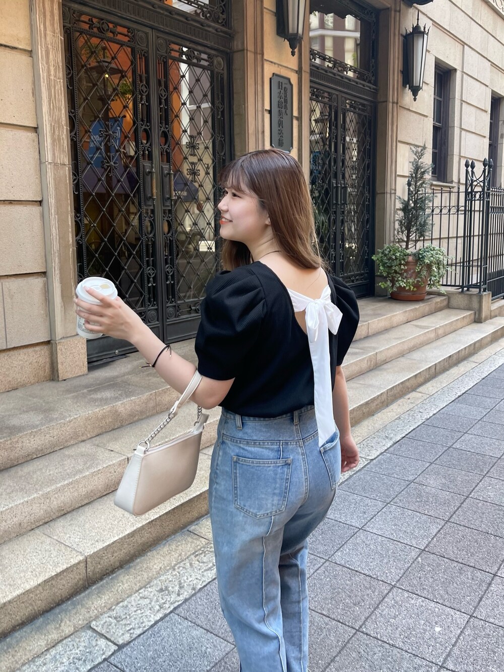 ホワイト系のショルダーバッグ、ブラック系のTシャツ/カットソー、ゴールド系のネックレスを着用したレディースの春コーディネートの2枚目の写真