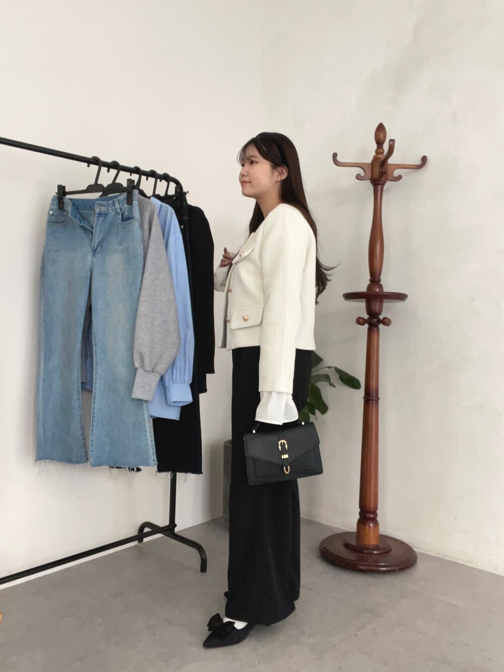 ホワイト系のノーカラージャケット、ホワイト系のニット/セーター、ブラック系のスラックスを着用したレディースの冬コーディネートの2枚目の写真