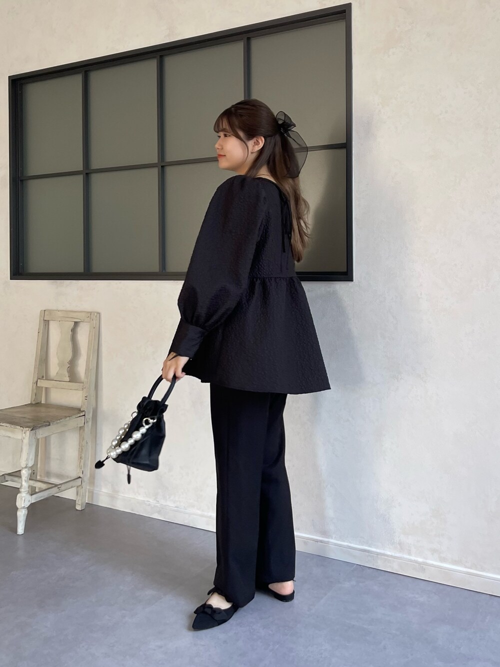 ブラック系のシャツ/ブラウス、ブラック系のスラックス、ブラック系のショルダーバッグを着用したレディースの秋コーディネートの2枚目の写真