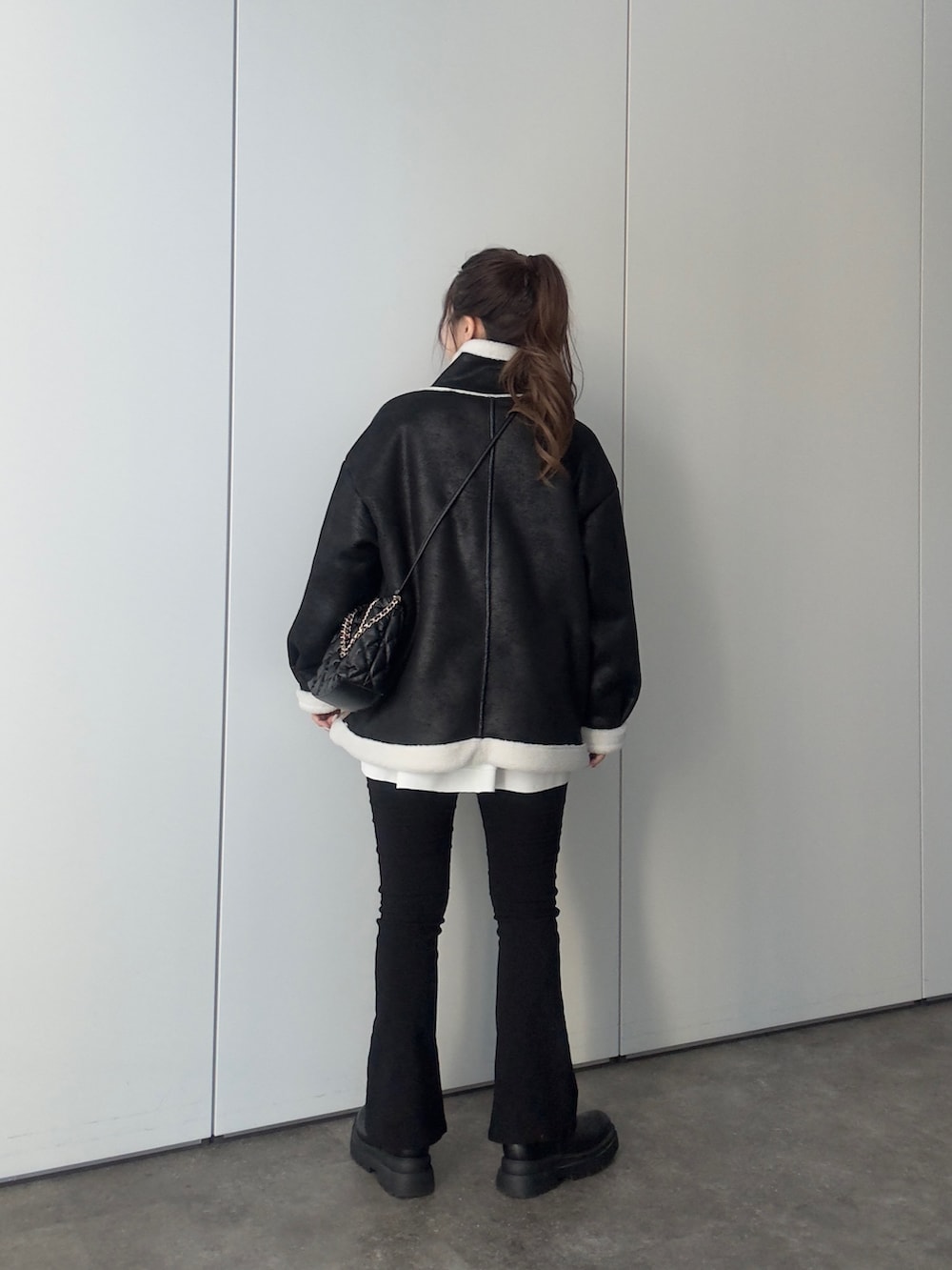 グレー系のTシャツ/カットソー、ブラック系のショルダーバッグ、ホワイト系のTシャツ/カットソーを着用したレディースの冬コーディネートの3枚目の写真