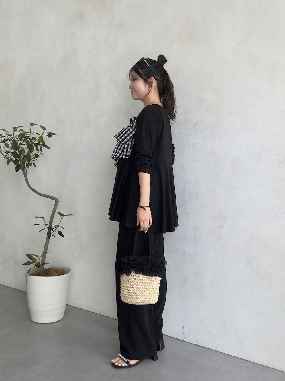 ブラック系のスラックス、ブラック系のサンダル、ブラック系のTシャツ/カットソーを着用したレディースの春コーディネートの2枚目の写真