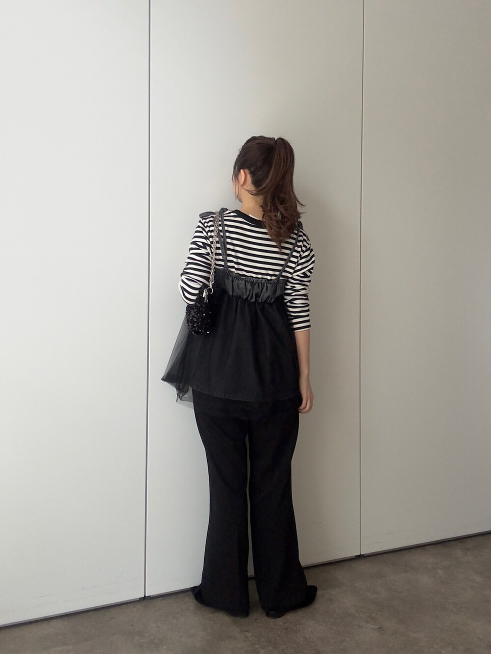 ブラック系のTシャツ/カットソー、ブラック系のショルダーバッグ、ブラック系のキャミソールを着用したレディースの春コーディネートの3枚目の写真