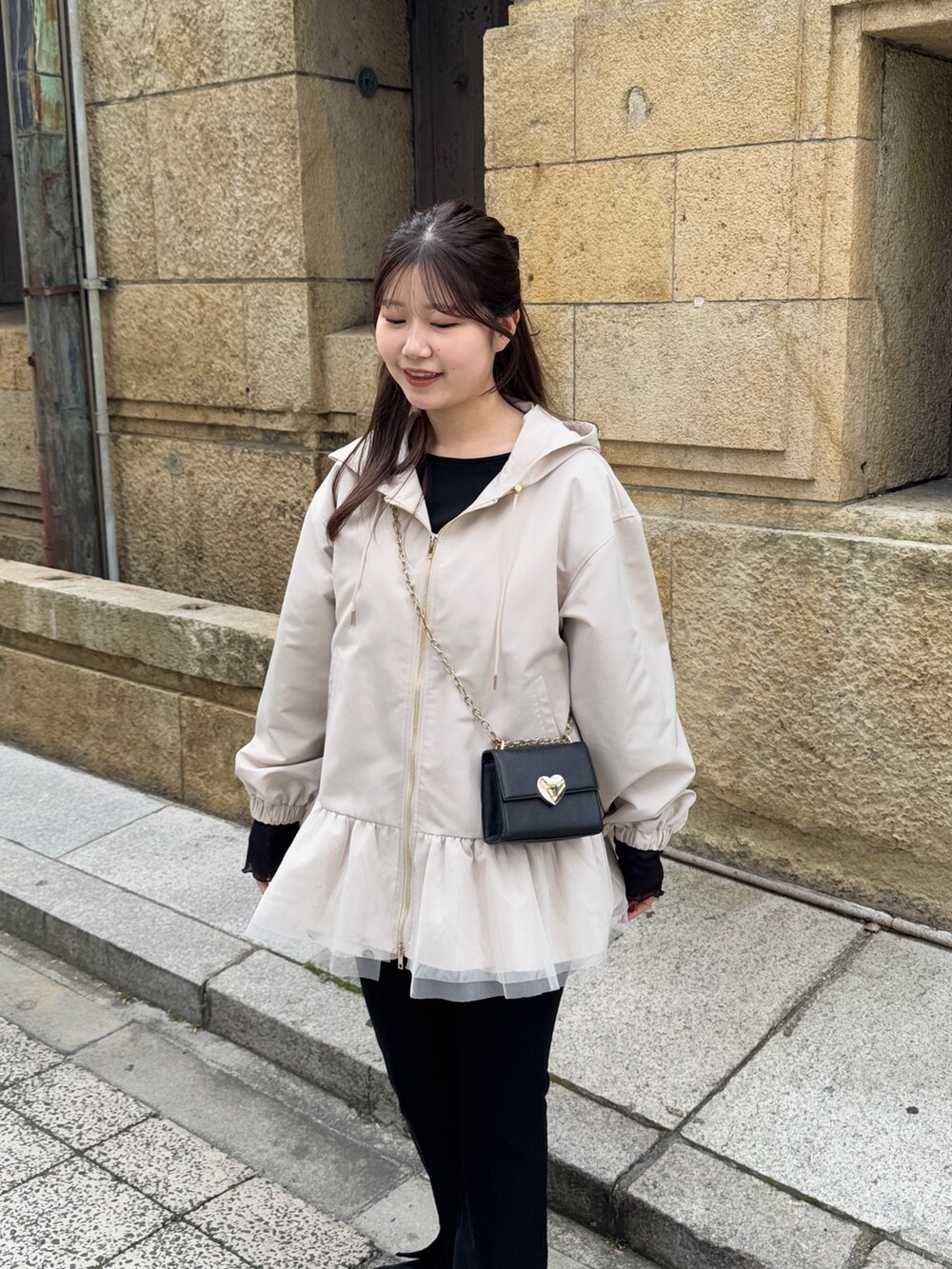 ブラック系のショルダーバッグ、ブラック系のTシャツ/カットソー、ホワイト系のキャミソールを着用したレディースの冬コーディネートの4枚目の写真